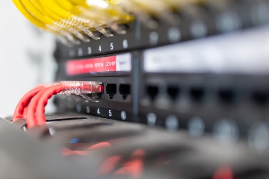 Gros plan sur un câble réseau Ethernet jaune connecté à un routeur ou modem internet