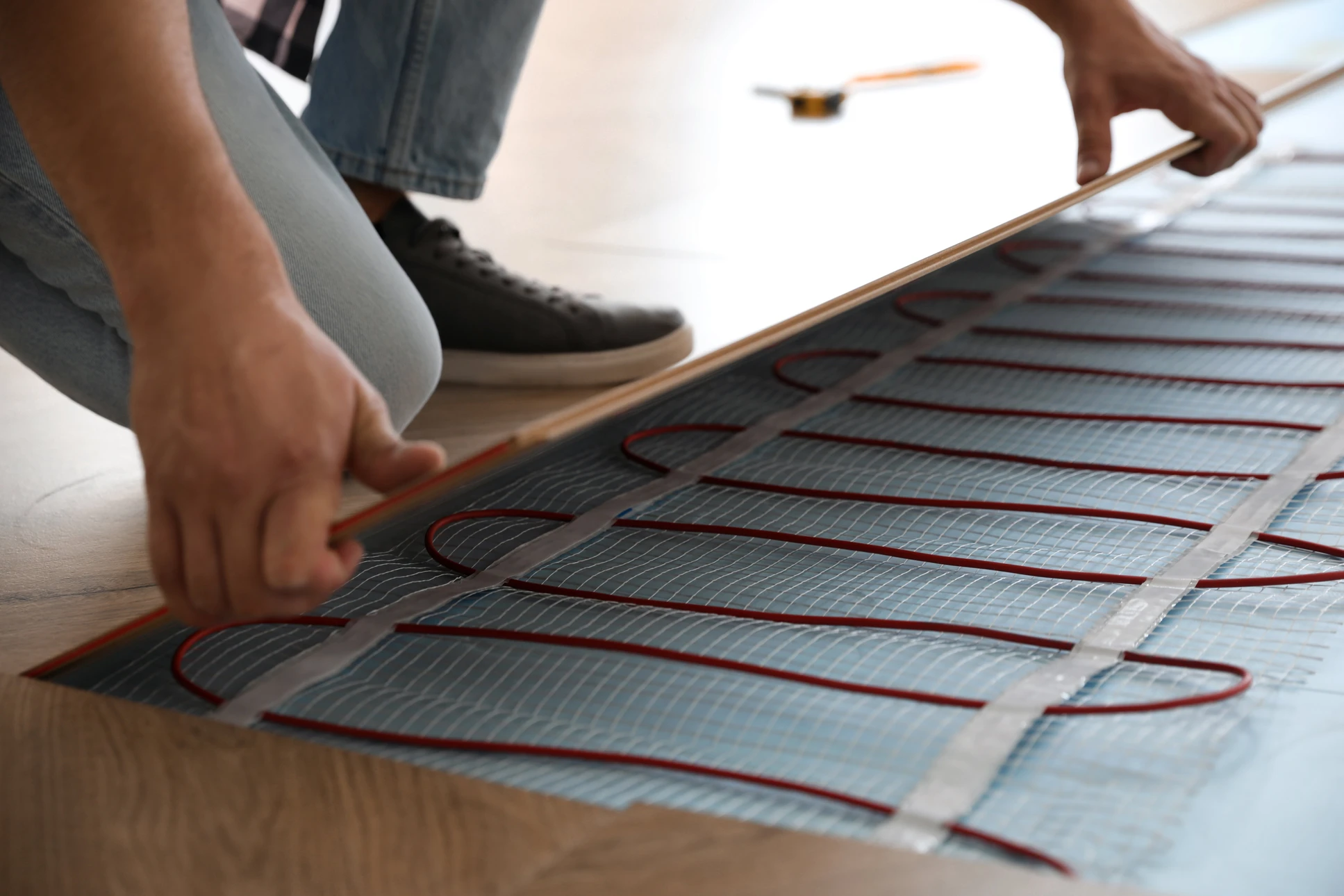Travailleur près des outils pour réparer le chapeau dur, la pince, le gant sur le sol chaud