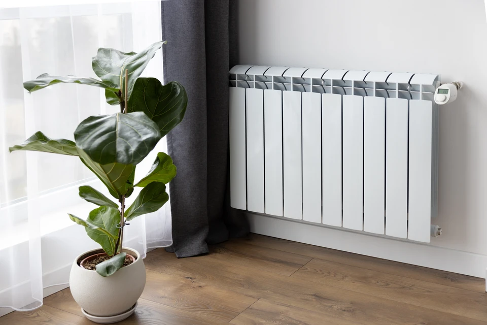 Intérieur moderne avec radiateur électrique blanc à convection installé en bas de mur